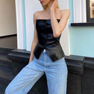 Haut en cuir sans bretelles noir, doté d'une coupe ajustée et d'une fermeture à boutons, parfait pour la mode estivale.