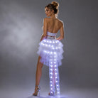 Woman wearing a white high-low LED tulle tutu skirt with integrated glowing lights and a remote-controlled battery system.