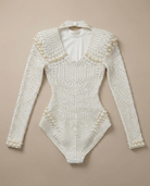 White pearl-embellished long sleeve bodysuit with a V-neck and figure-hugging stretch fit.