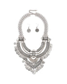 Set di collana e orecchini bohemien con metallo argento antico, design intricato a moneta e nappine giocose.